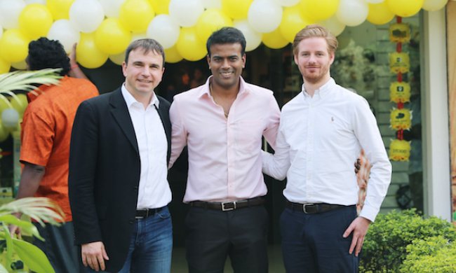 3 men standing in front of yellow balloons