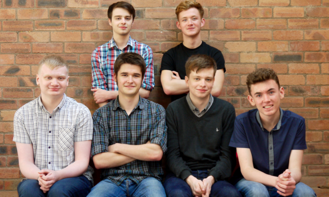 6 men in front of brick wall