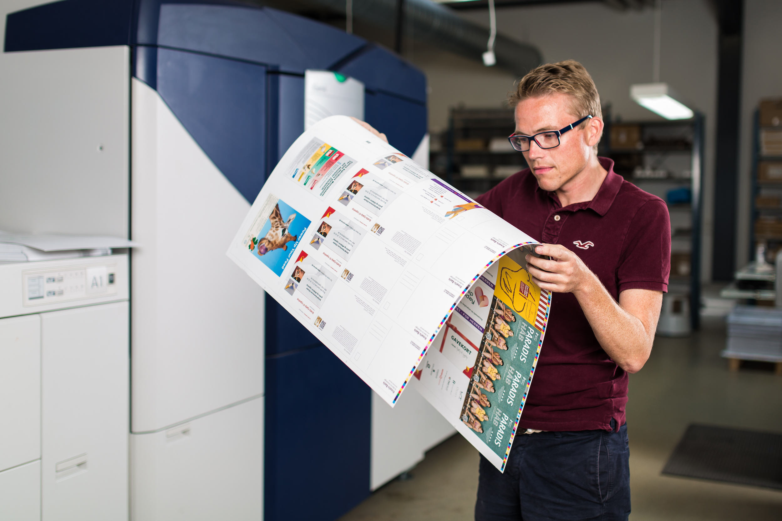 Man infront of Xerox Printer examining print