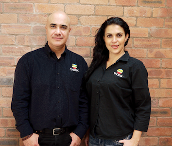 Alejandro Gamboa and Mariana Maldonado in front of brick wall