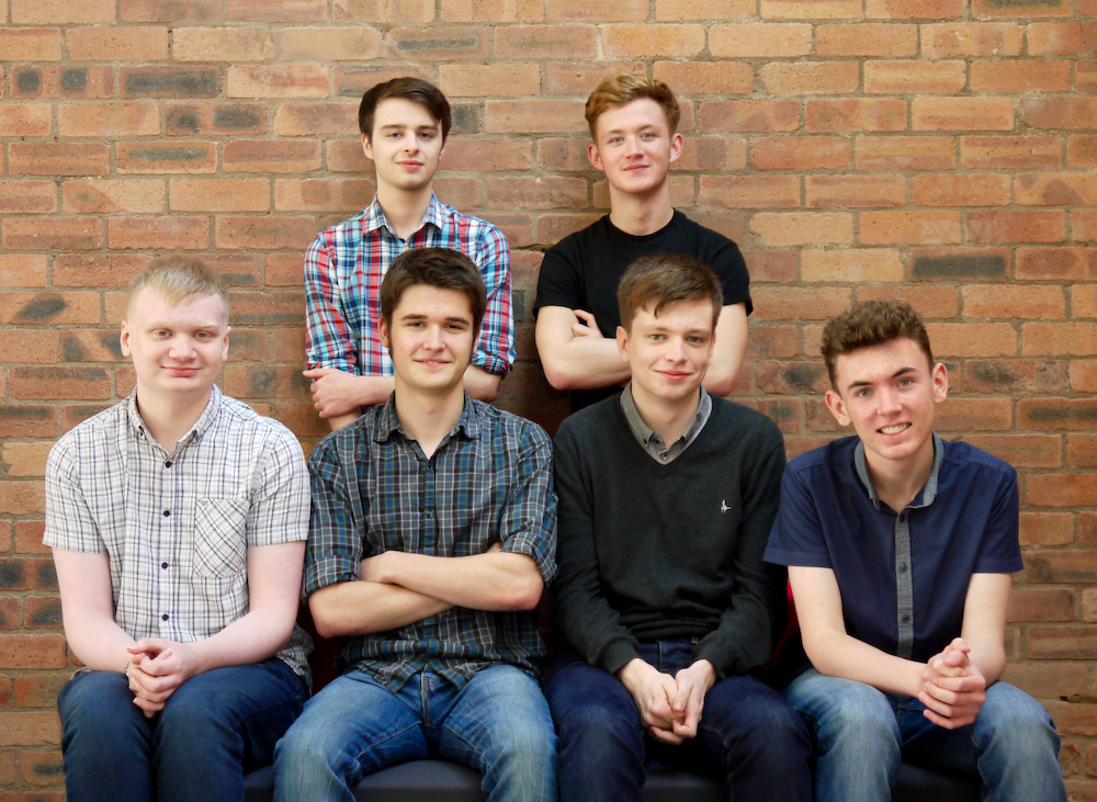 6 men in front of brick wall